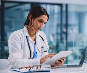 A doctor looking at a tablet