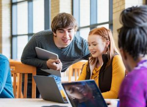 A group of students looking at a laptop