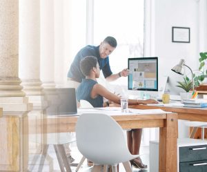 Two professionals having a discussion in front of a computer screen