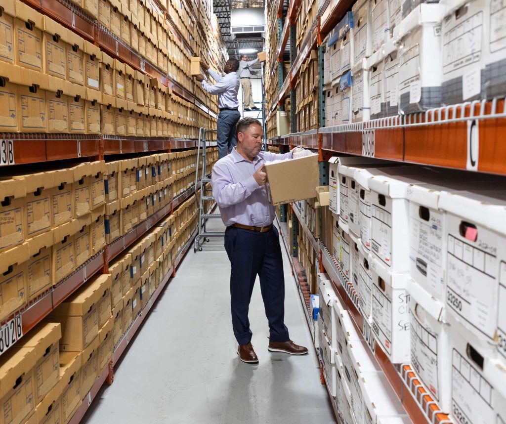 A QAI employee putting a box on a shelf