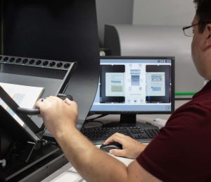 A QAI employee operating a piece of document conversion equipment