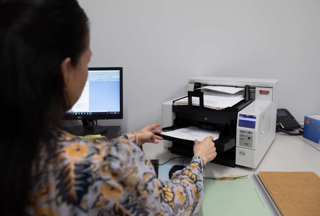 A QAI employee scanning a document