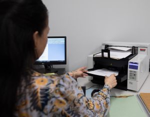 A QAI employee scanning documents