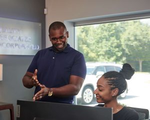 Two QAI employees viewing a laptop screen