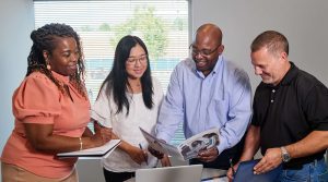 A group of QAI employees discussing a project