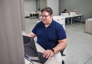 A QAI employee working at a computer